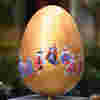 A beautifully designed golden egg on a stand